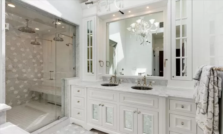 Full bathroom with double vanity, a sink, and a shower stall