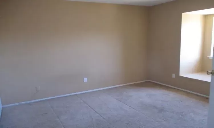 Unfurnished room featuring carpet and baseboards