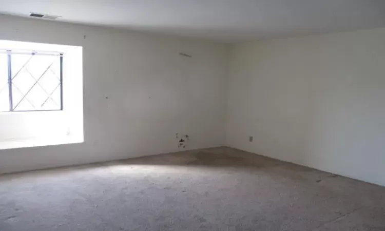 Unfurnished room with carpet and visible vents