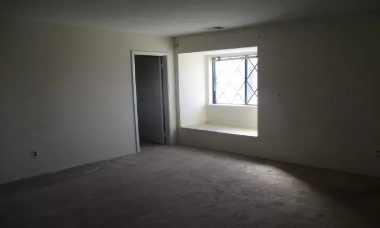 Unfurnished room with visible vents and carpet flooring