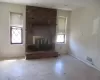 Unfurnished living room featuring a fireplace, visible vents, and baseboards