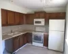 Kitchen featuring light countertops, white appliances, backsplash, and a sink