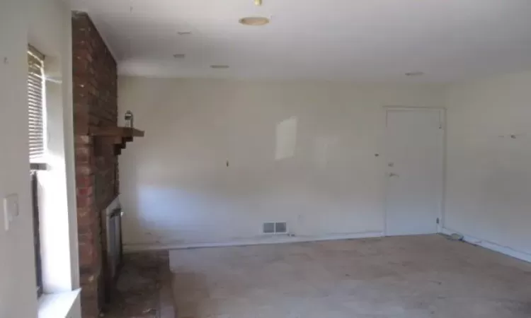 Spare room featuring visible vents and a fireplace