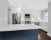 Kitchen featuring stainless steel appliances, a sink, light stone countertops, dark wood finished floors, and crown molding