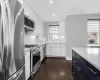 Kitchen featuring stainless steel appliances, light stone counters, and white cabinets