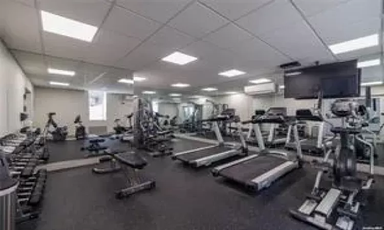 Exercise room with a paneled ceiling and a wall mounted AC