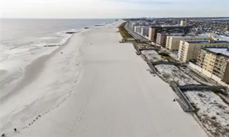 Aerial view featuring a water view and a beach view