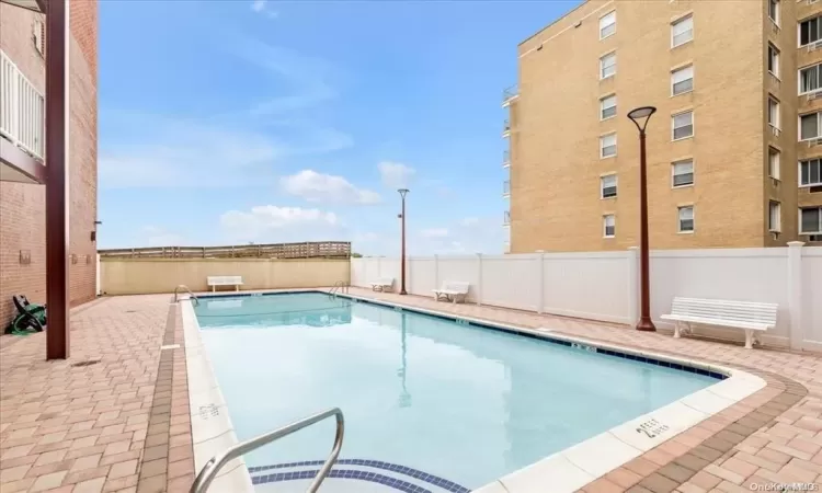 Pool with a patio area and fence