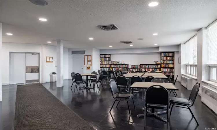 Dining area featuring radiator, visible vents, a textured ceiling, and recessed lighting