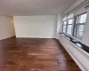 Spare room featuring dark wood-style floors and baseboards