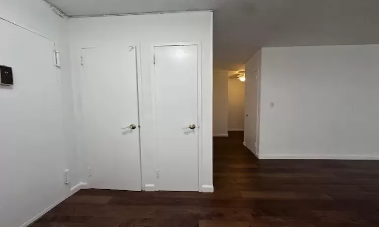 Hallway featuring baseboards and wood finished floors