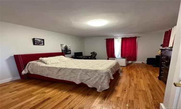 Bedroom with light wood-style floors and baseboards