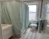 Full bathroom featuring tile walls, toilet, and vanity