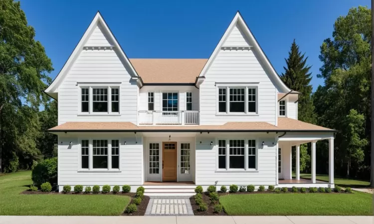 View of front of house featuring a balcony, covered porch, a front lawn, and roof with shingles