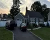 View of front of property with a garage, a yard, driveway, and fence