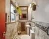 Bathroom with toilet, wainscoting, and tile walls