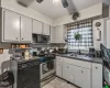 Kitchen with a toaster, dark countertops, a ceiling fan, a sink, and black appliances