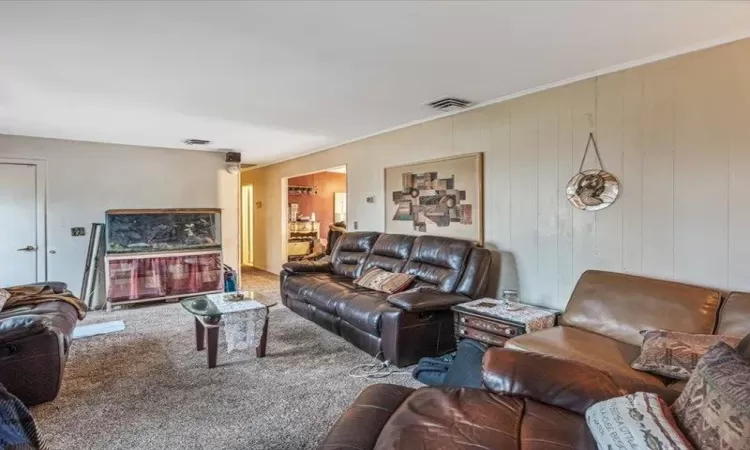 Carpeted living area featuring visible vents