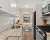 Kitchen featuring stainless steel appliances, backsplash, a sink, and white cabinetry