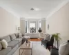 Living area featuring radiator, crown molding, and wood finished floors