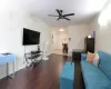 Living room featuring baseboards, radiator heating unit, a ceiling fan, and wood finished floors