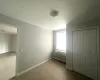 Unfurnished bedroom with a closet, a wall mounted air conditioner, wood finished floors, and baseboards