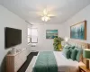 Bedroom with radiator heating unit, dark carpet, ceiling fan, and baseboards