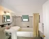 Bathroom with shower / bath combo with shower curtain, tile walls, and tile patterned floors