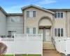 Townhome / multi-family property featuring fence and stucco siding