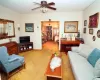 Living area with light carpet and ceiling fan with notable chandelier