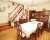 Dining room with carpet floors, stairs, and a notable chandelier