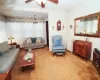 Living area with ceiling fan, carpet, and radiator