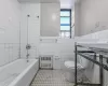 Full bathroom with shower / bath combination, toilet, radiator heating unit, tile patterned floors, and tile walls