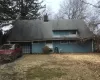 Rear view of house with an attached garage and a chimney