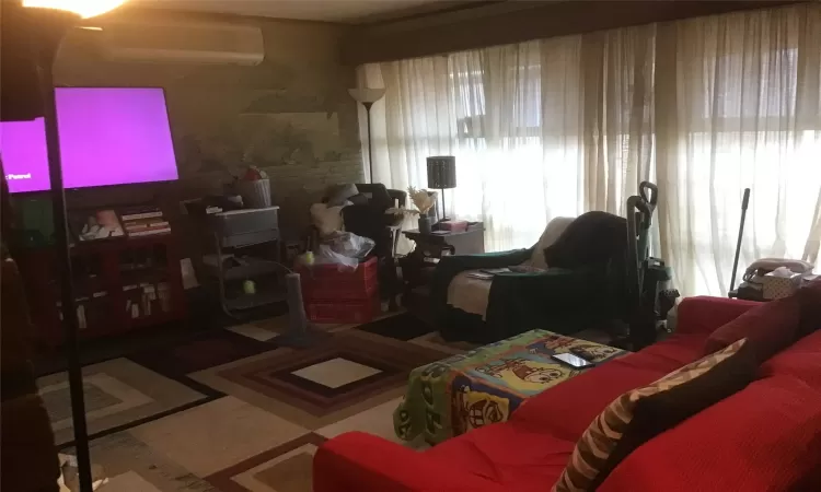 Living area with a wealth of natural light and a wall mounted AC