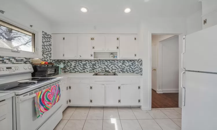 Finished below grade area featuring recessed lighting, light wood-type flooring, and baseboards