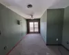 Carpeted Bedroom with an AC wall unit, visible vents, ceiling fan, and baseboards