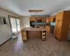 Kitchen featuring electric panel, brown cabinetry, dark countertops, black appliances, and a sink