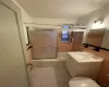 Bathroom featuring tile walls, toilet, combined bath / shower with glass door, vanity, and tile patterned floors