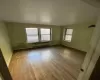 Unfurnished room featuring radiator heating unit and wood-type flooring