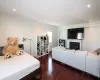 Bedroom featuring recessed lighting, a glass covered fireplace, and hardwood / wood-style floors