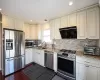 Kitchen with light stone counters, stainless steel appliances, a sink, visible vents, and tasteful backsplash