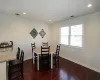 Dining space with dark wood-style floors, visible vents, and baseboards