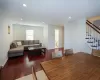 Living area featuring wood-type flooring, stairs, baseboards, and recessed lighting