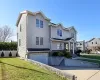 View of front facade featuring an attached garage, a residential view, fence, and a front yard