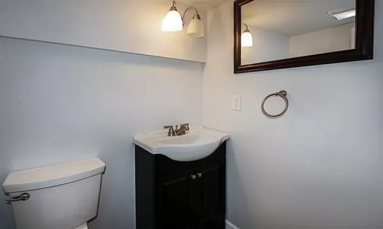 Bathroom with toilet, baseboards, and vanity