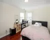 Bedroom with dark wood-style floors, ornamental molding, visible vents, and baseboards