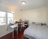 Bedroom with baseboards, visible vents, ornamental molding, and wood finished floors