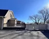 View of home's exterior with a shingled roof and a gate