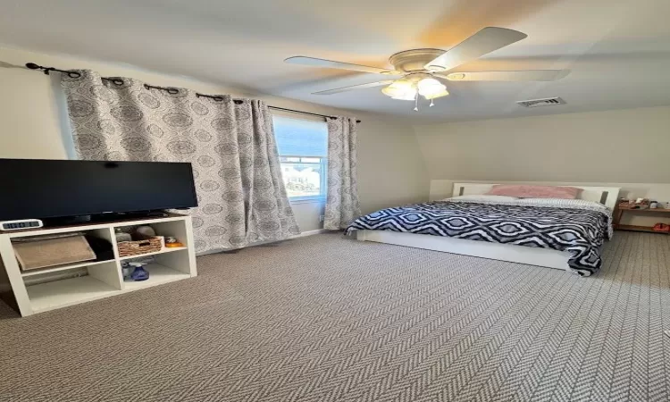 Carpeted bedroom with ceiling fan and visible vents